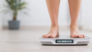 Personne debout sur une balance illustrant le lien entre poids, émotions et croyances inconscientes.
